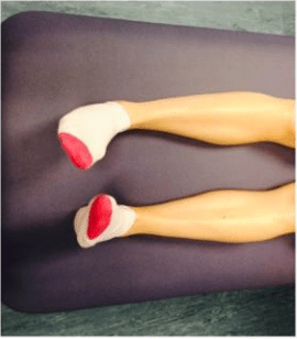 Person turning their feet inwards while lying or sitting with their legs in front of them.